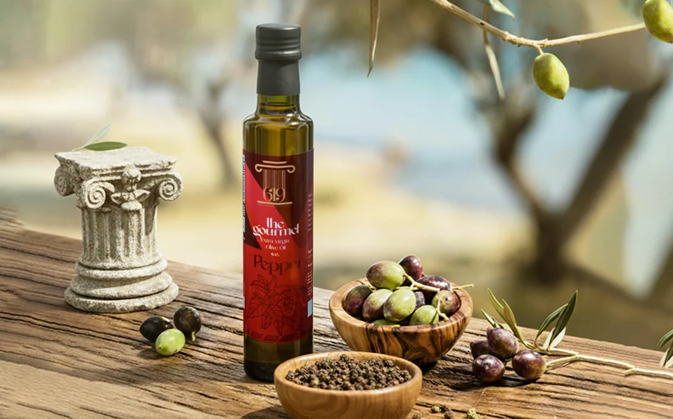 The Gourmet pepper-infused olive oil by 619 on a rustic table with an Ionic column, olives and a bowl of peppercorns